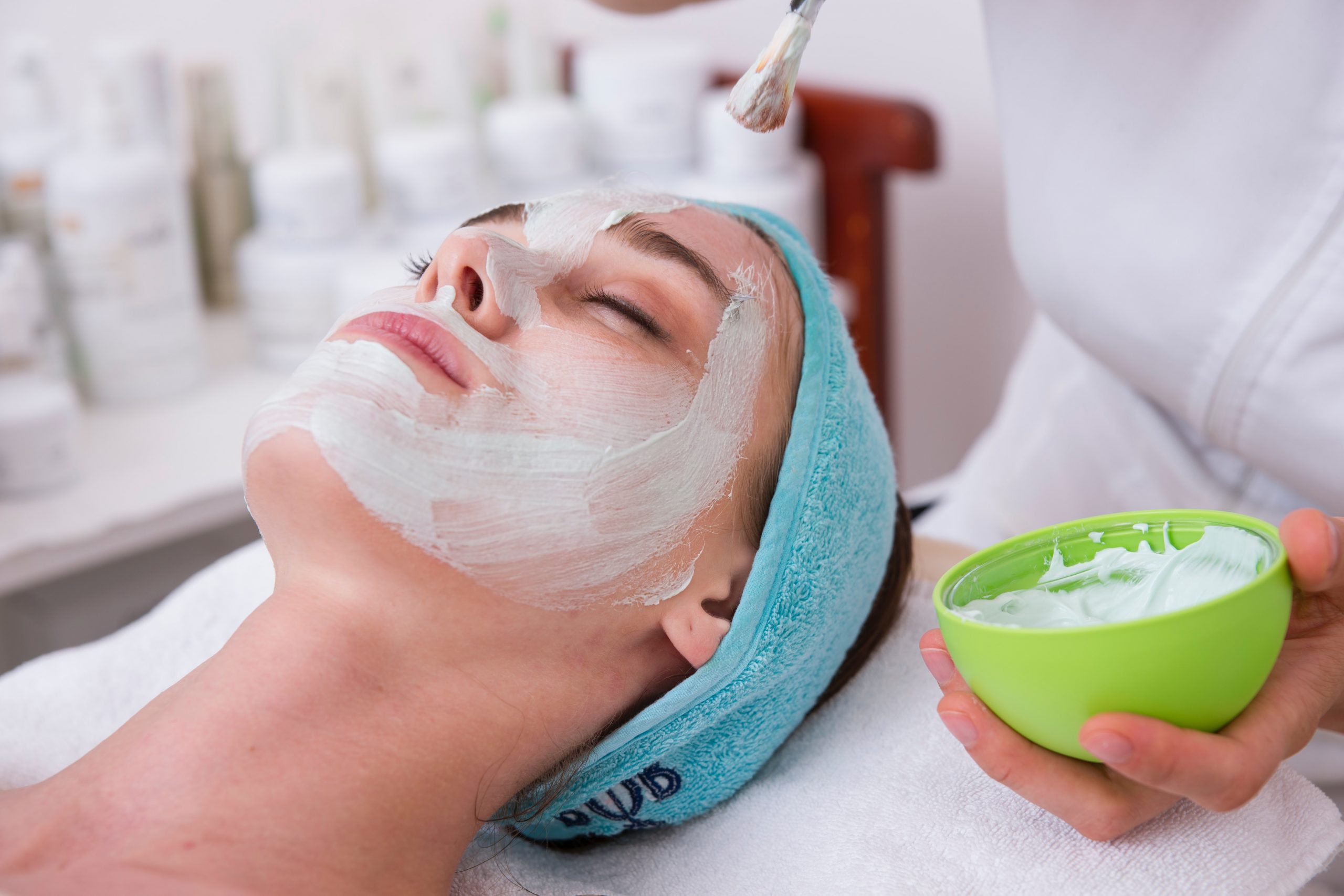 A woman getting her face washed with a towel.