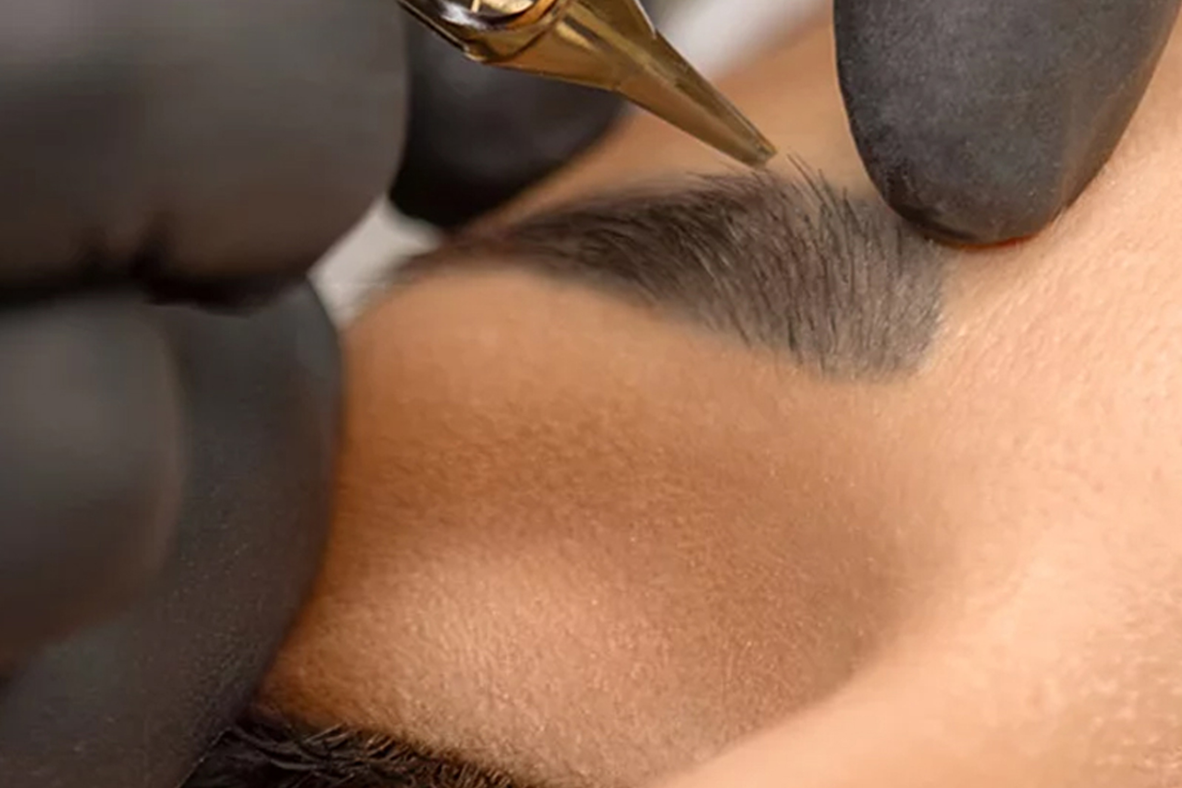 A person getting their eyebrows tattooed