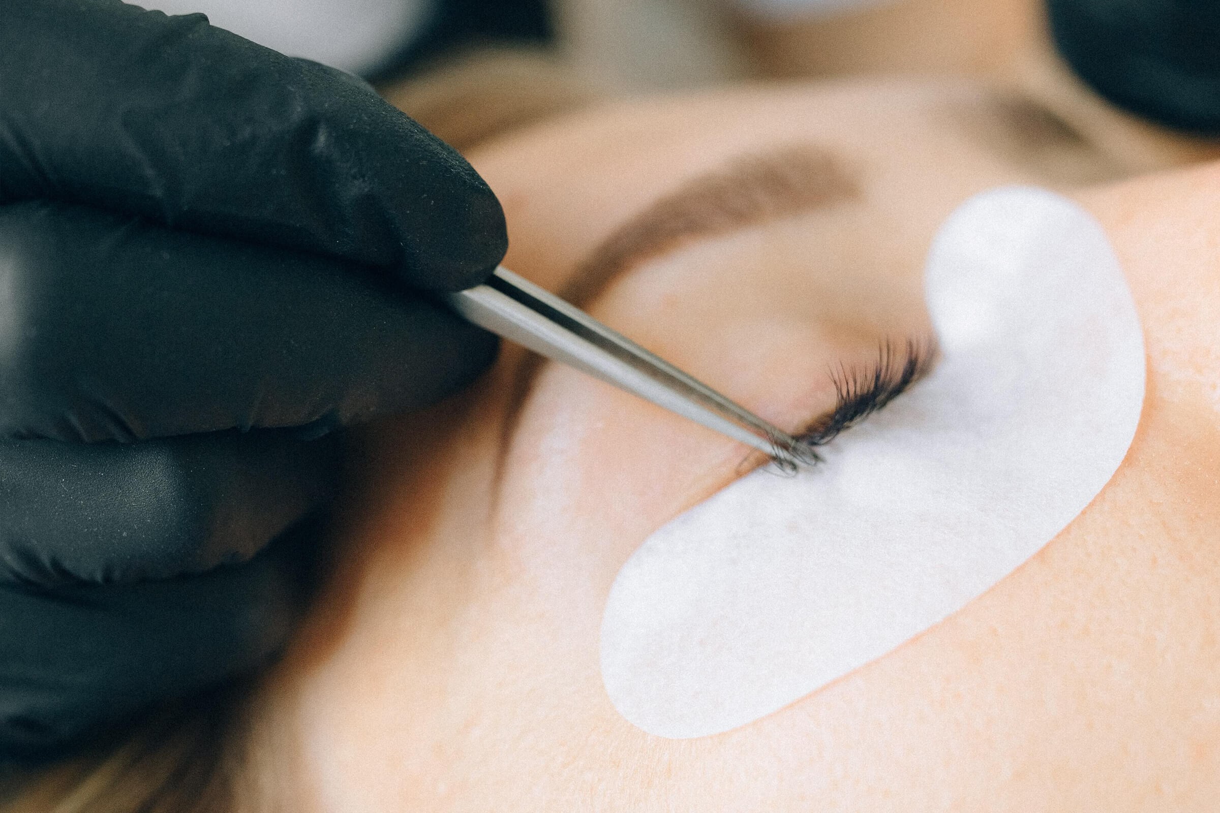 A person is getting their eyelashes trimmed